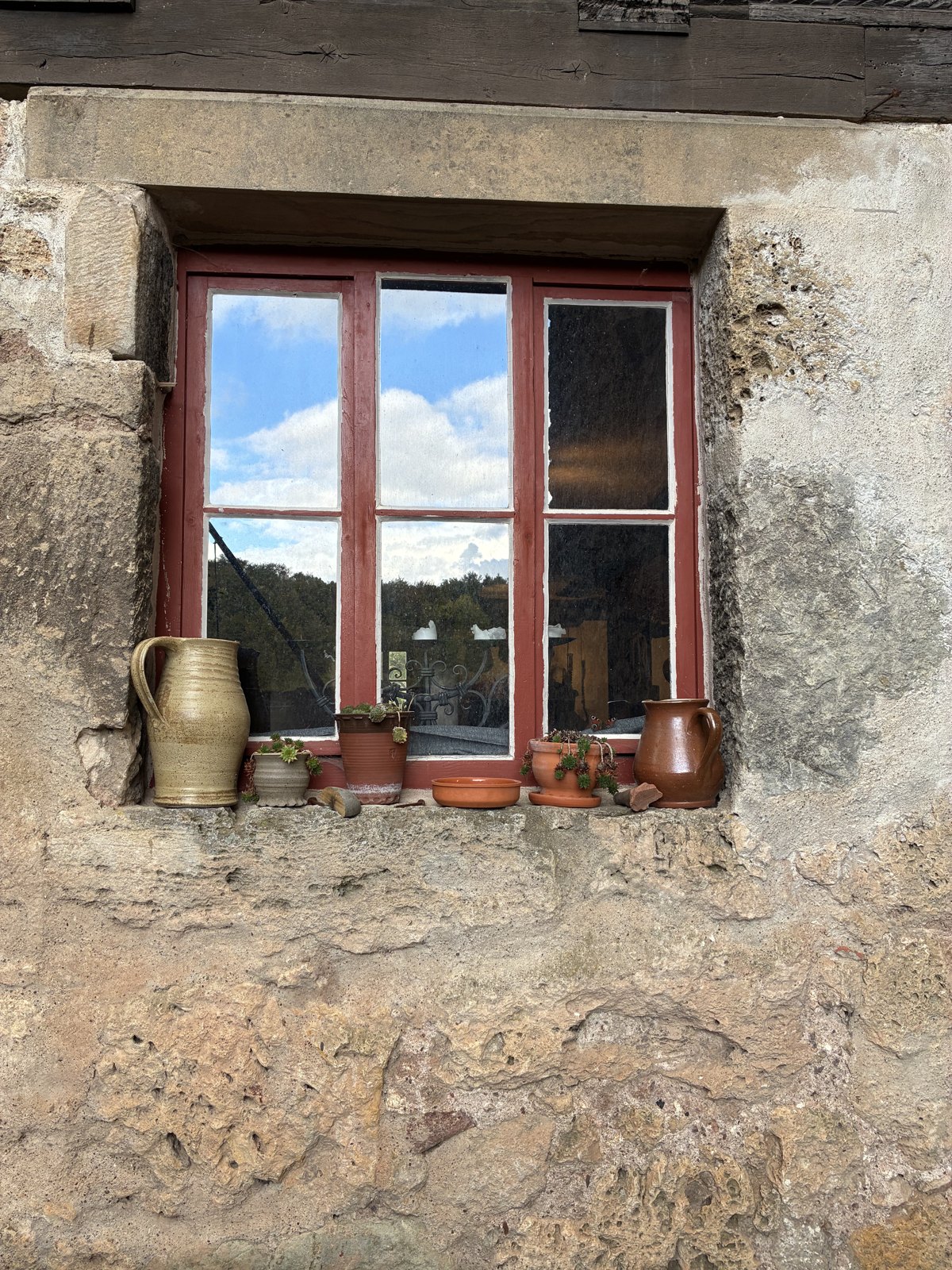 Fenster mit Steinzeugkrügen in der Burgmauer