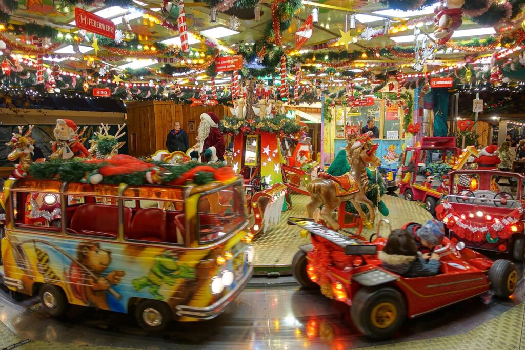 Kinderkarussell mit kleinen Fahrzeugen auf einem Weihnachtsmarkt